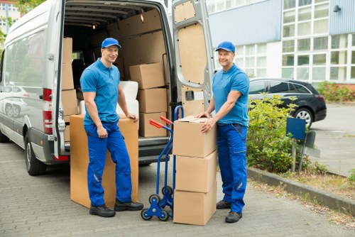 Professional removalists carrying furniture through local streets.